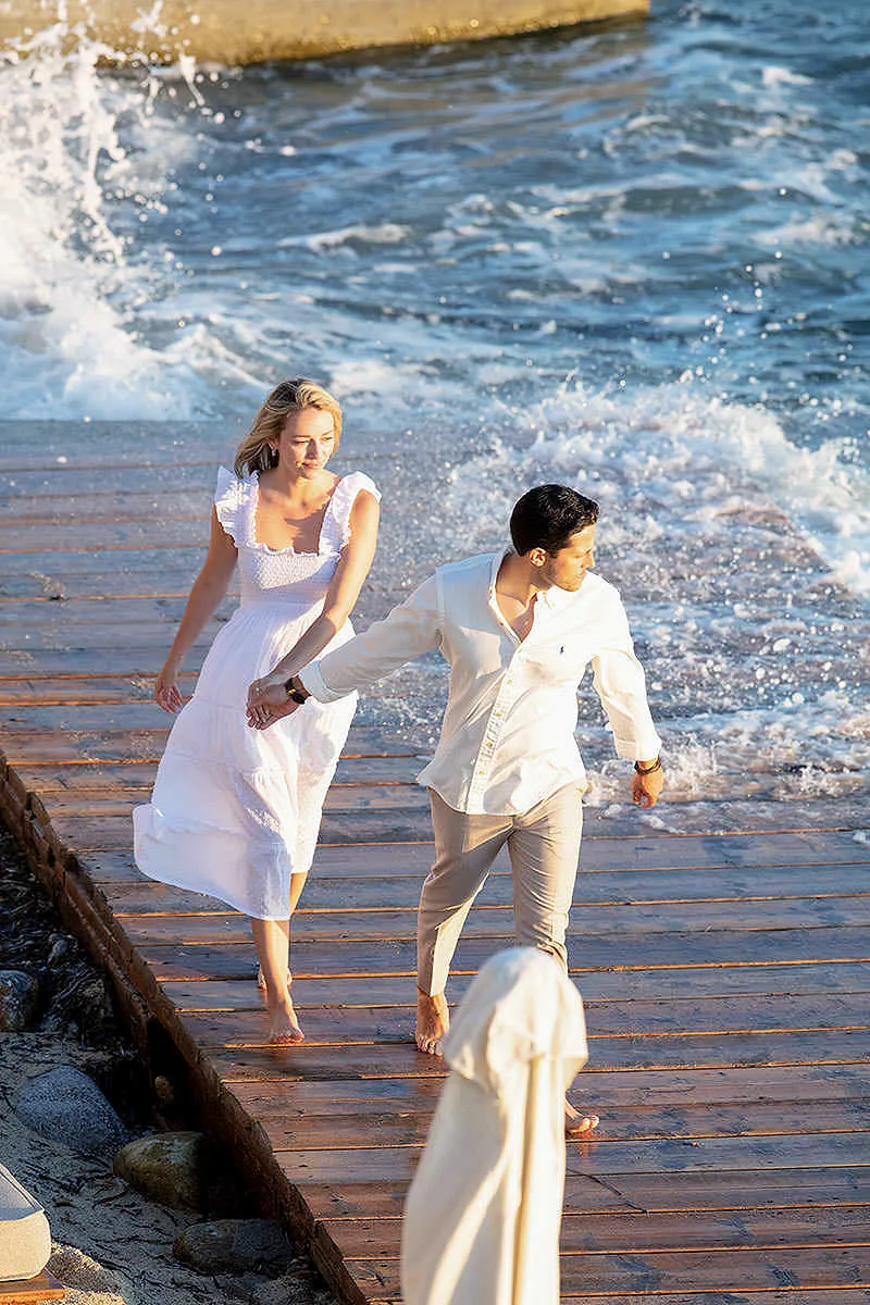 Sunlit beach wedding proposal moment in Mykonos, Greece