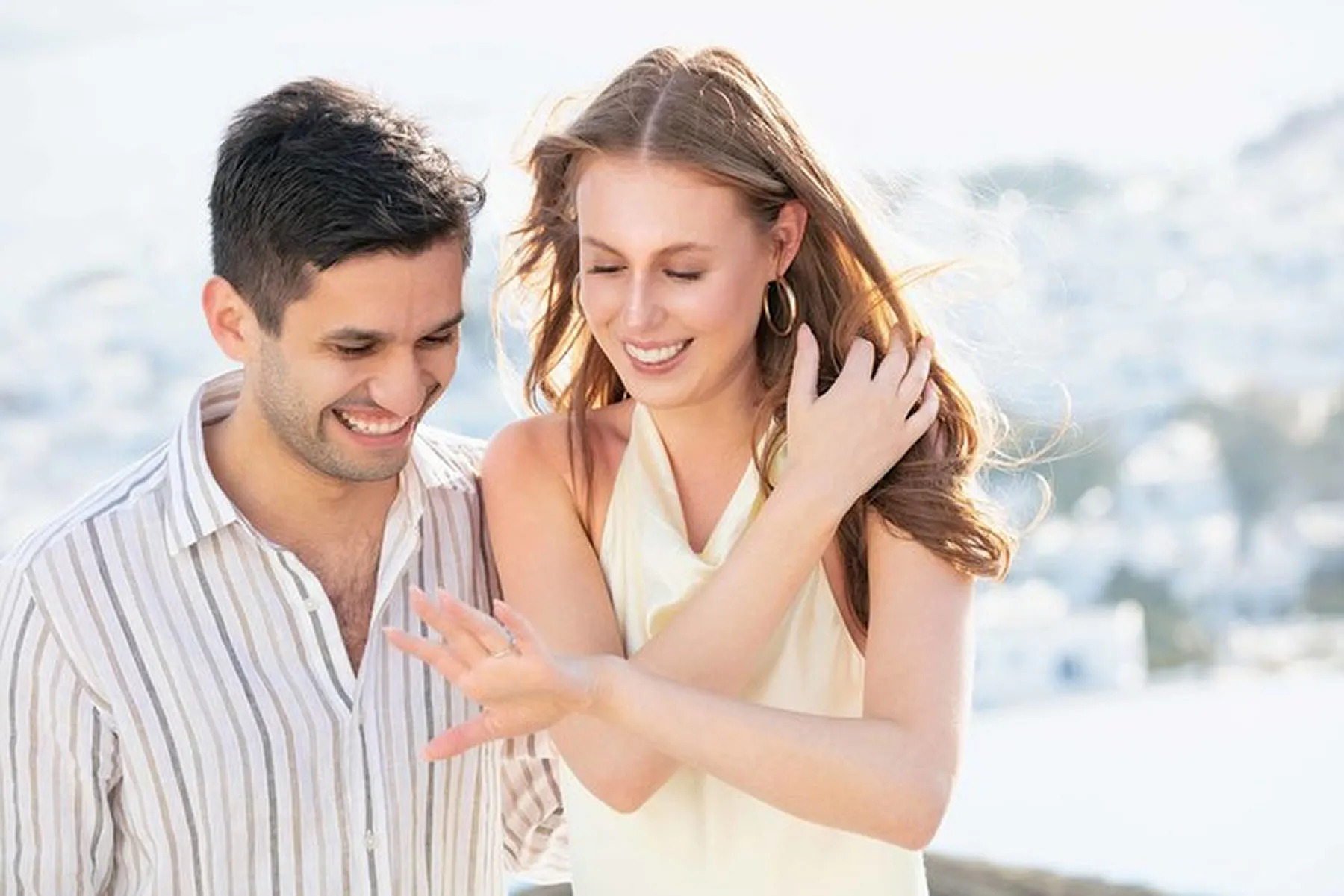 Sunlit stone arch wedding proposal composition in Mykonos, Greece