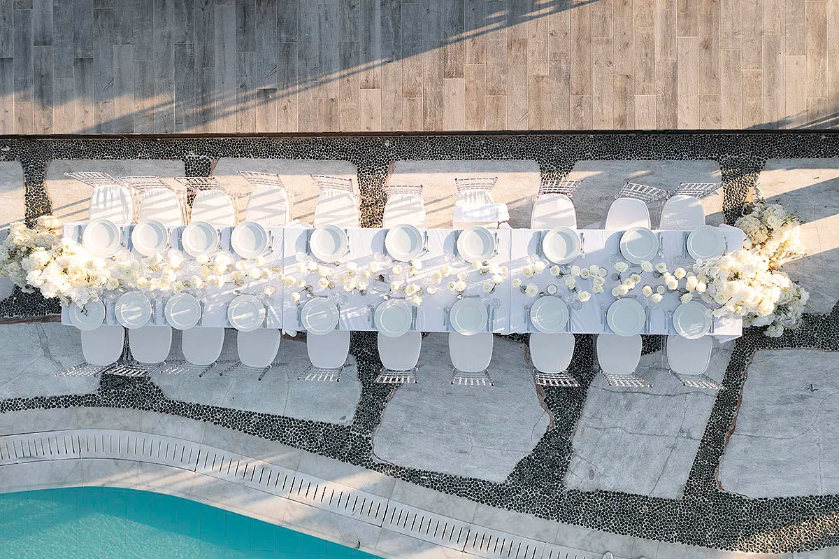 Sunlit aerial drone wedding photography at a whitewashed chapel, in Mykonos, Greece