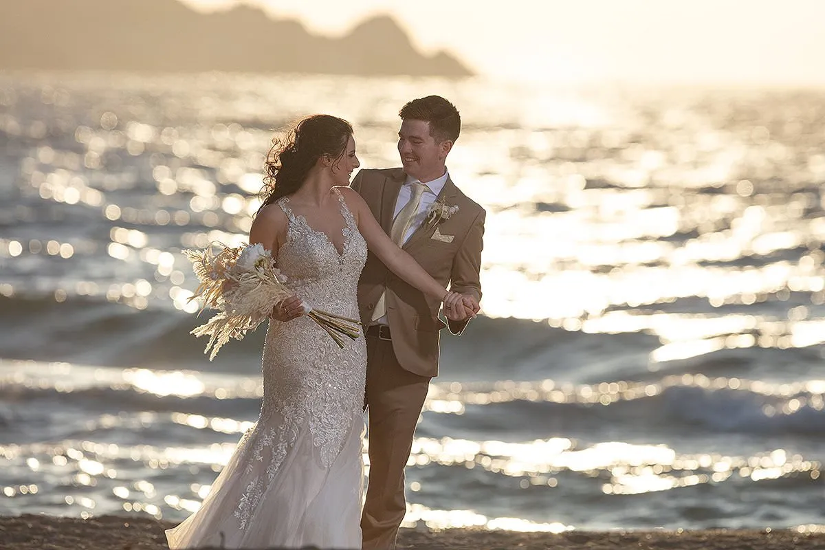 Sunlit beach wedding photography at a whitewashed chapel, in Mykonos, Greece