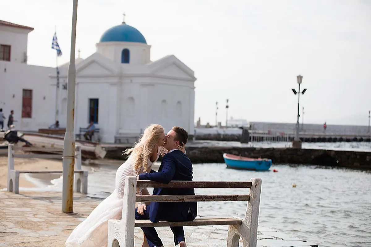 Sunlit blue dome chapel wedding photography by a blue dome, in Mykonos, Greece