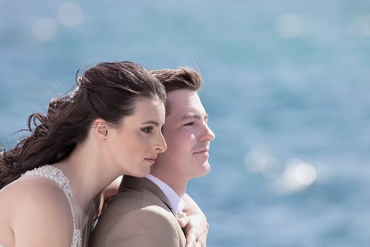 Sunlit ceremony wedding photography by a blue dome, in Mykonos, Greece