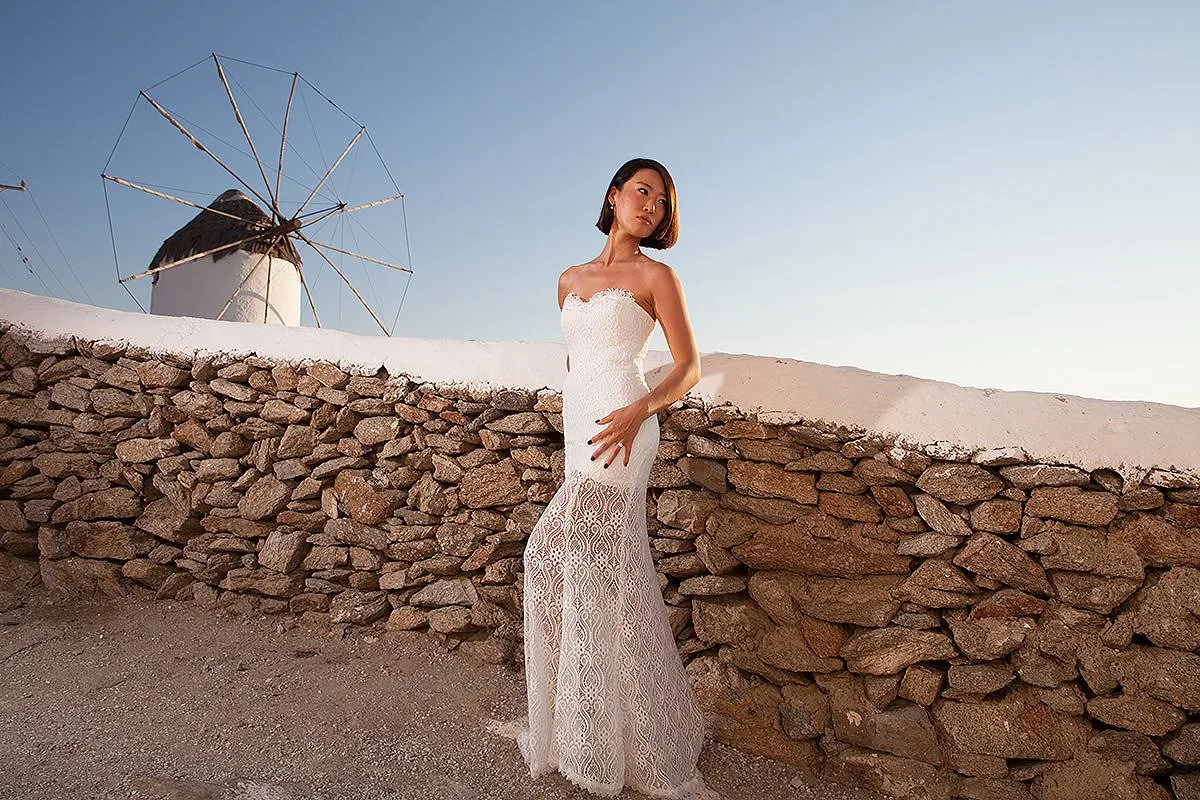 Sunlit classic wedding photography by a blue dome, in Mykonos, Greece