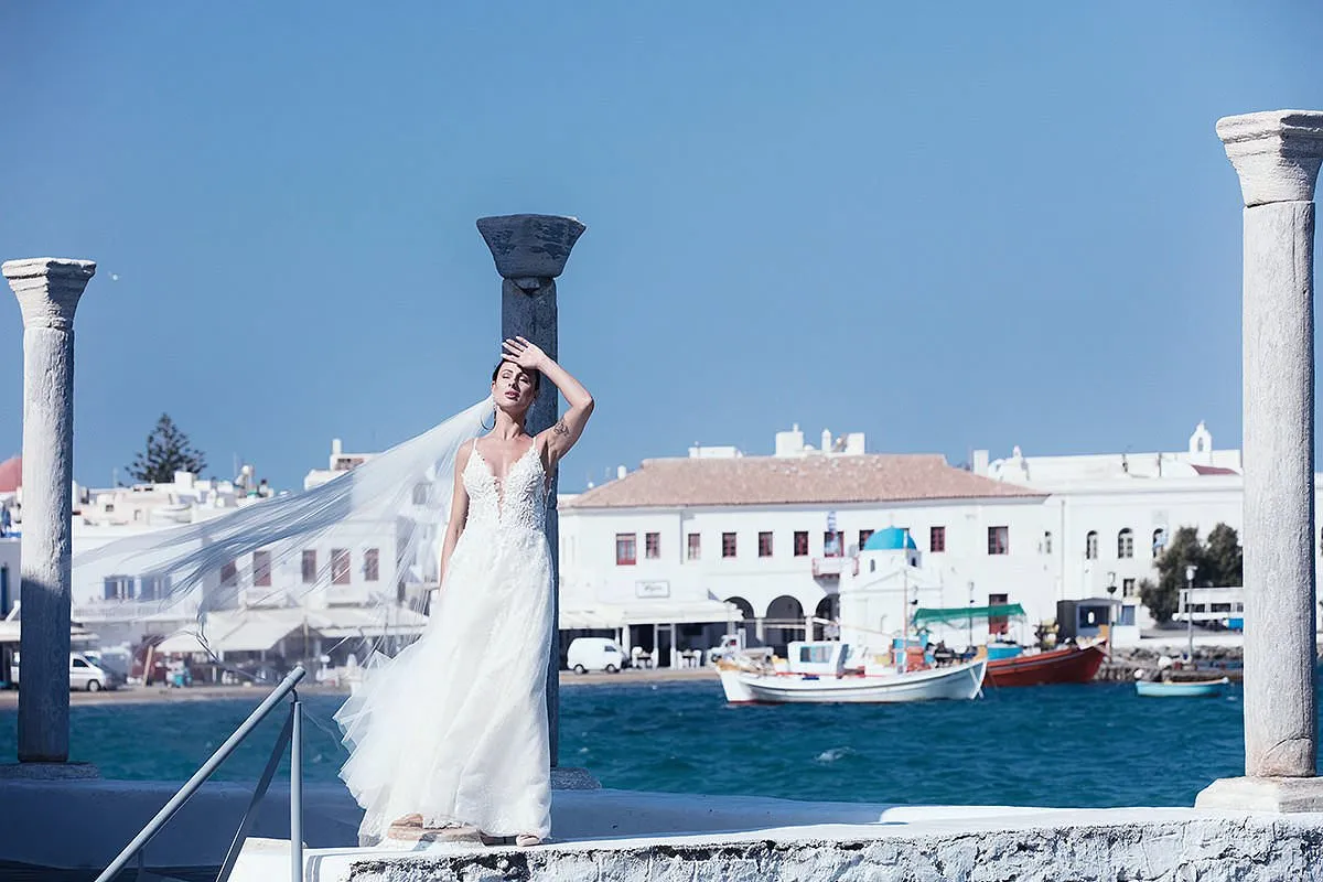 Sunlit clifftop wedding photography at a whitewashed chapel, in Mykonos, Greece