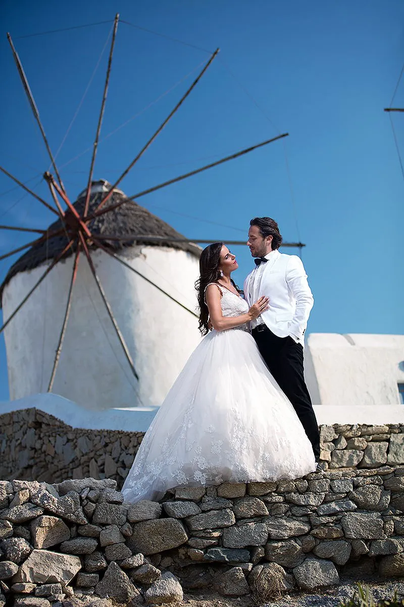 Sunlit dancefloor wedding photography by a blue dome, in Mykonos, Greece