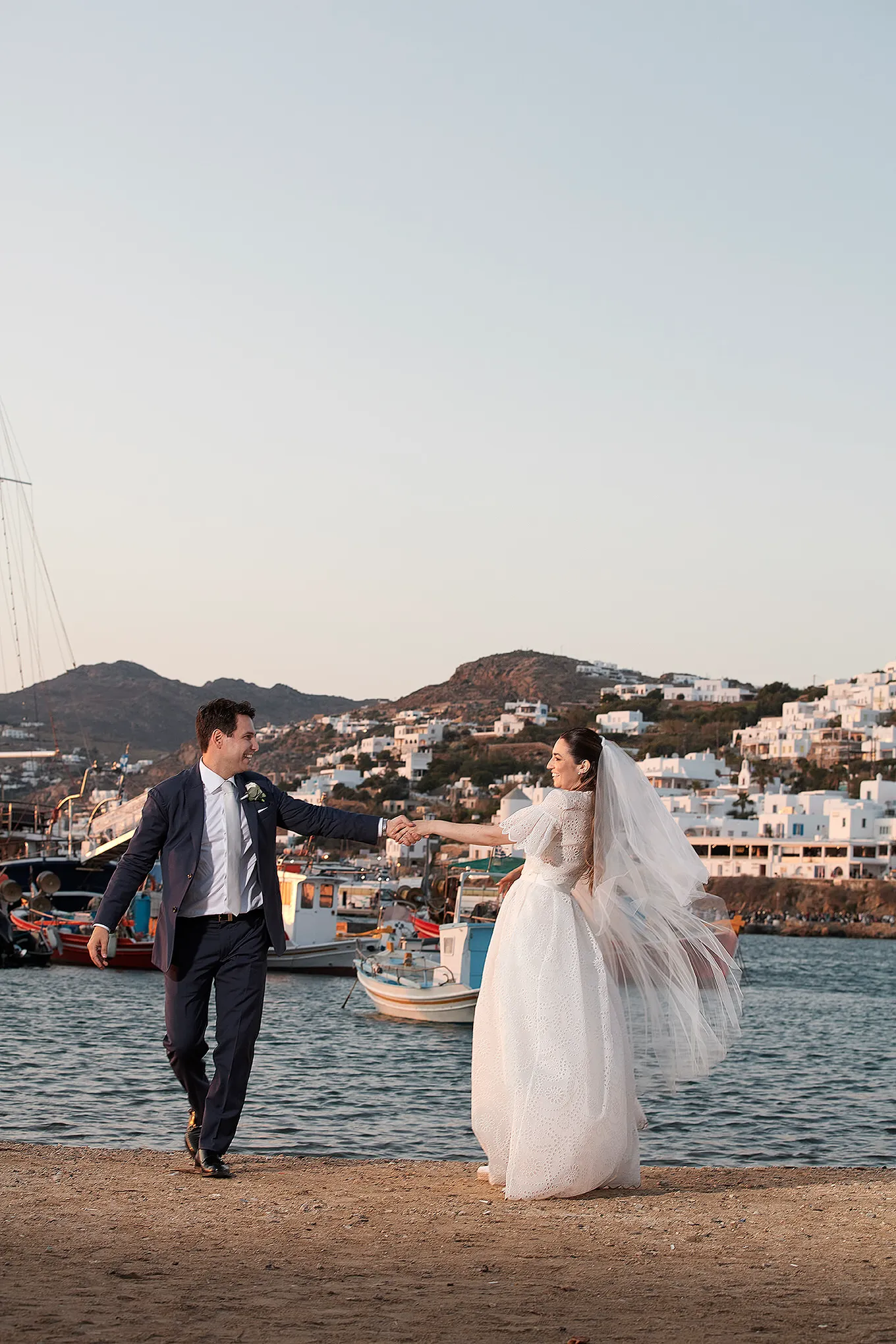 Sunlit documentary wedding photography by a blue dome, in Mykonos, Greece