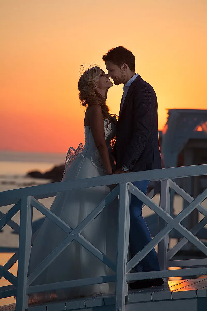 Sunlit editorial couple wedding photography by a blue dome, in Mykonos, Greece
