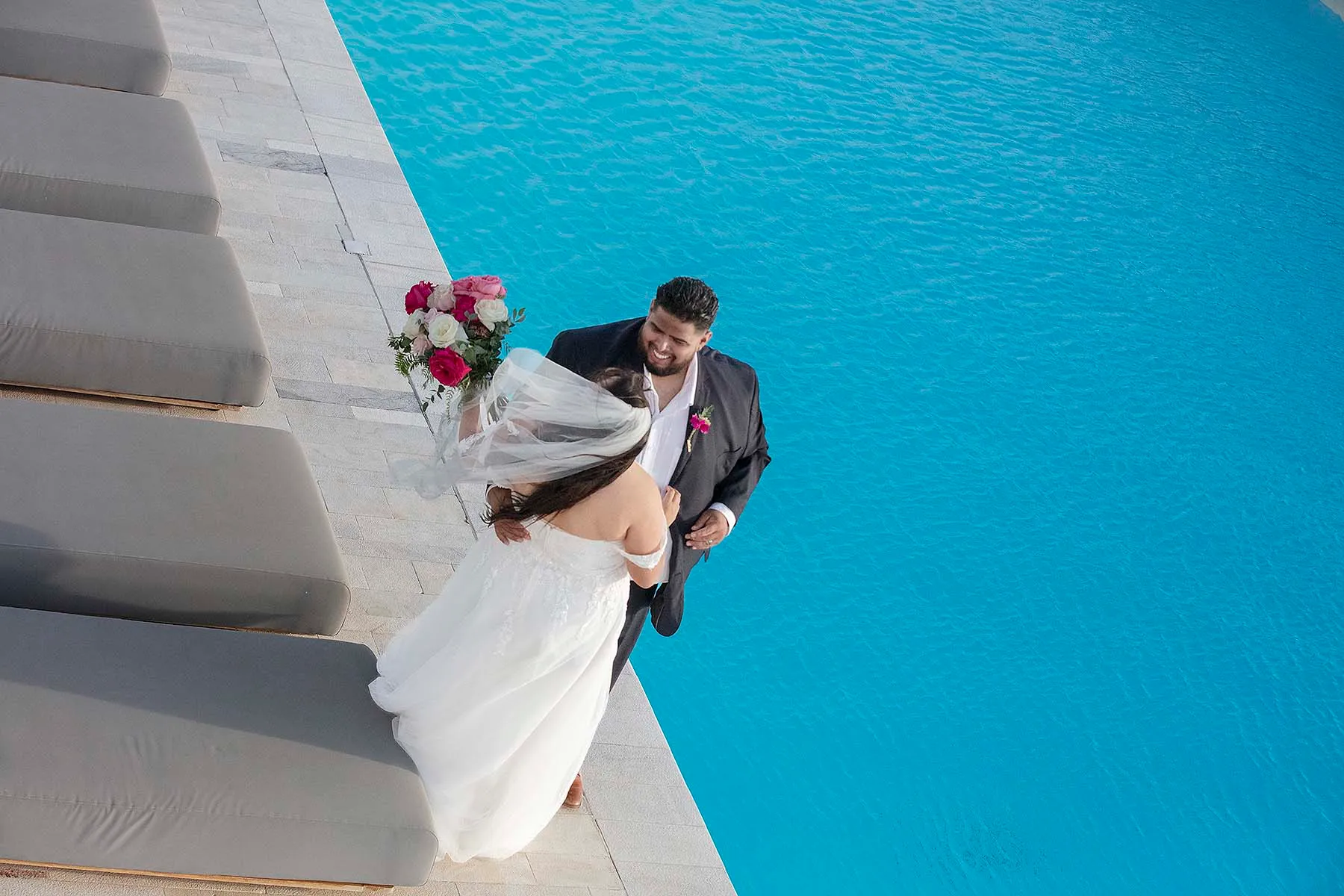 Sunlit golden hour wedding photography by a blue dome, in Mykonos, Greece