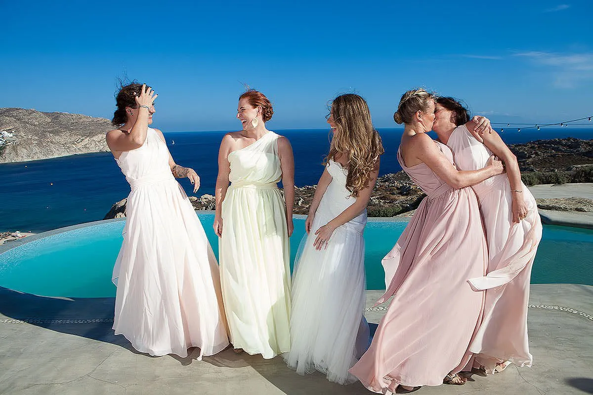 Sunlit groom editorial wedding photography by a blue dome, in Mykonos, Greece