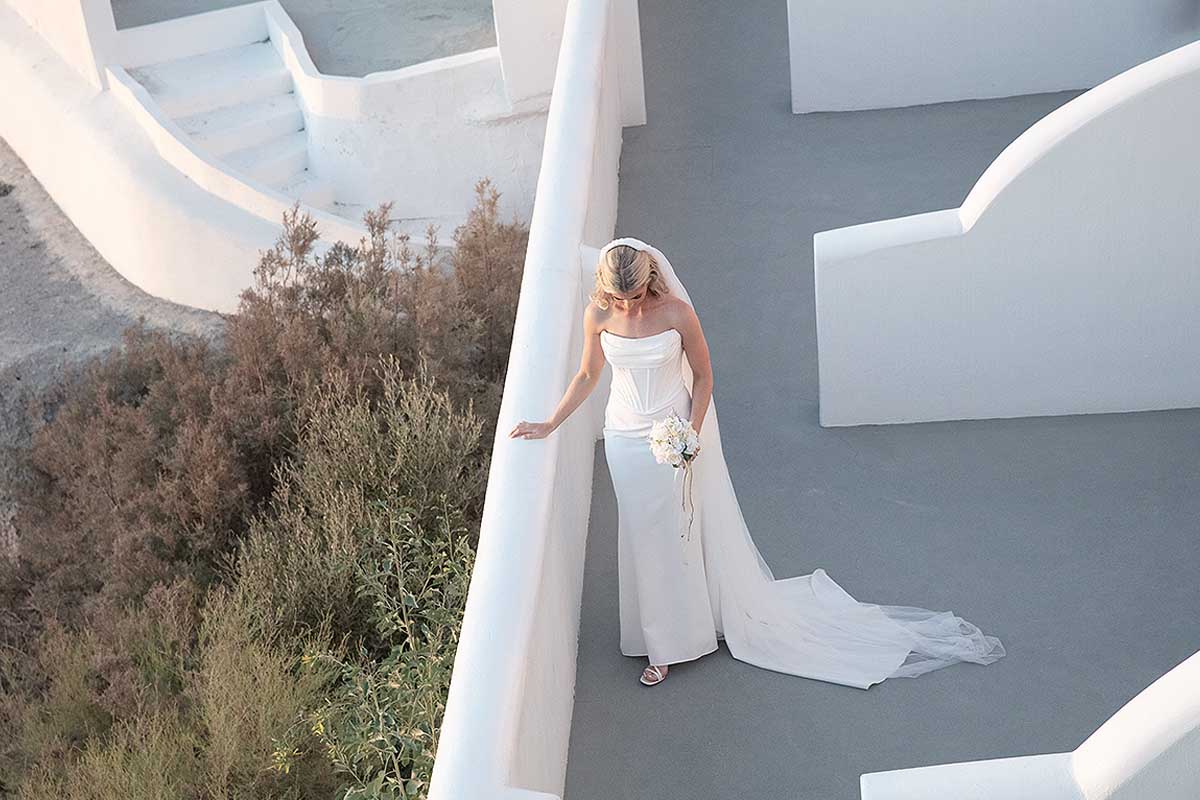 Sunlit harbor wedding photography by a blue dome, in Mykonos, Greece