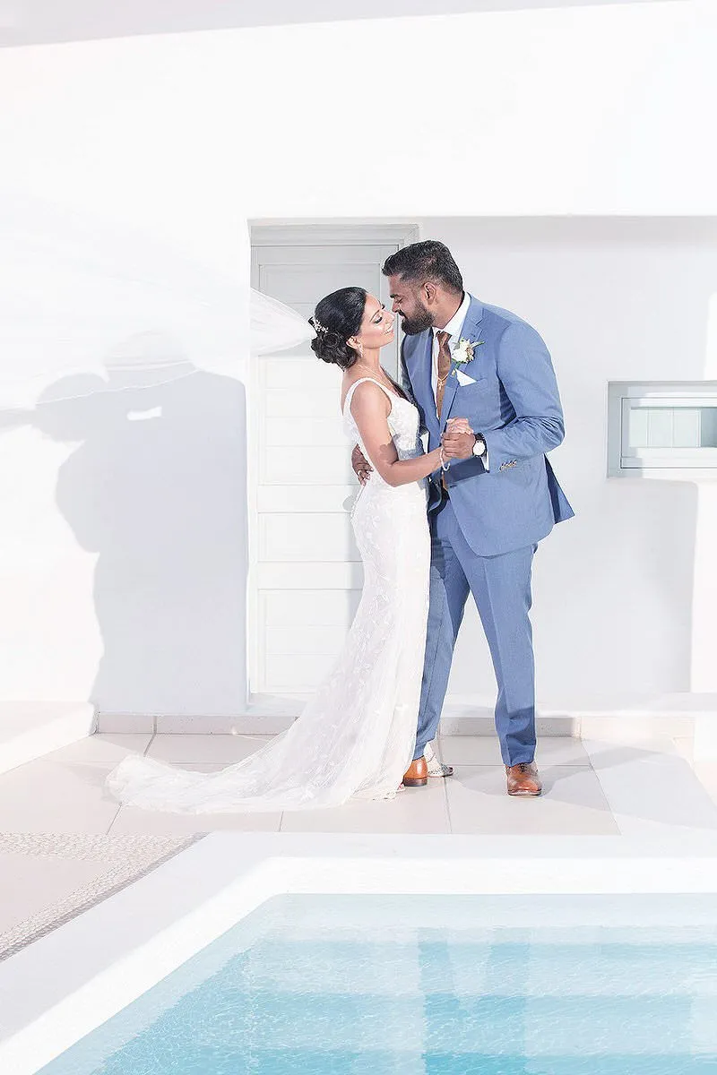 Sunlit reception wedding photography by a blue dome, in Mykonos, Greece