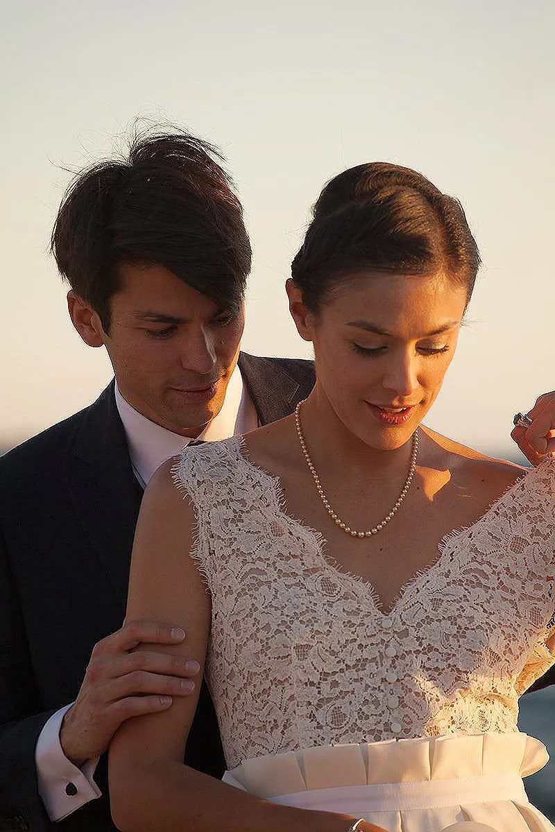 Sunlit romantic wedding photography by a blue dome, in Mykonos, Greece