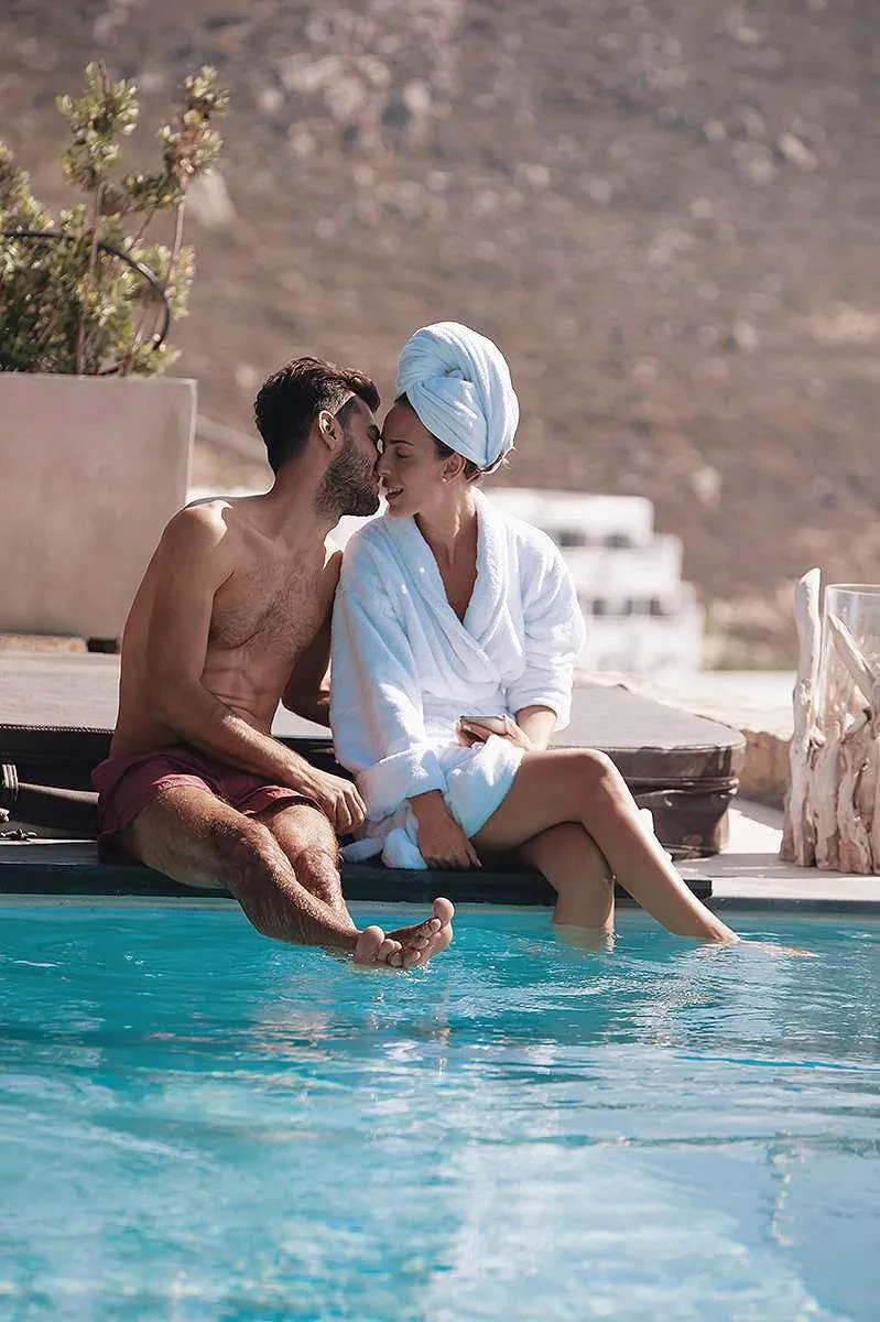 Sunlit rooftop wedding photography by a blue dome, in Mykonos, Greece
