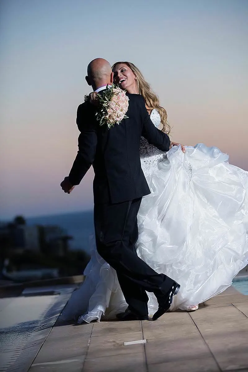 Sunlit sunset wedding photography at a whitewashed chapel, in Mykonos, Greece