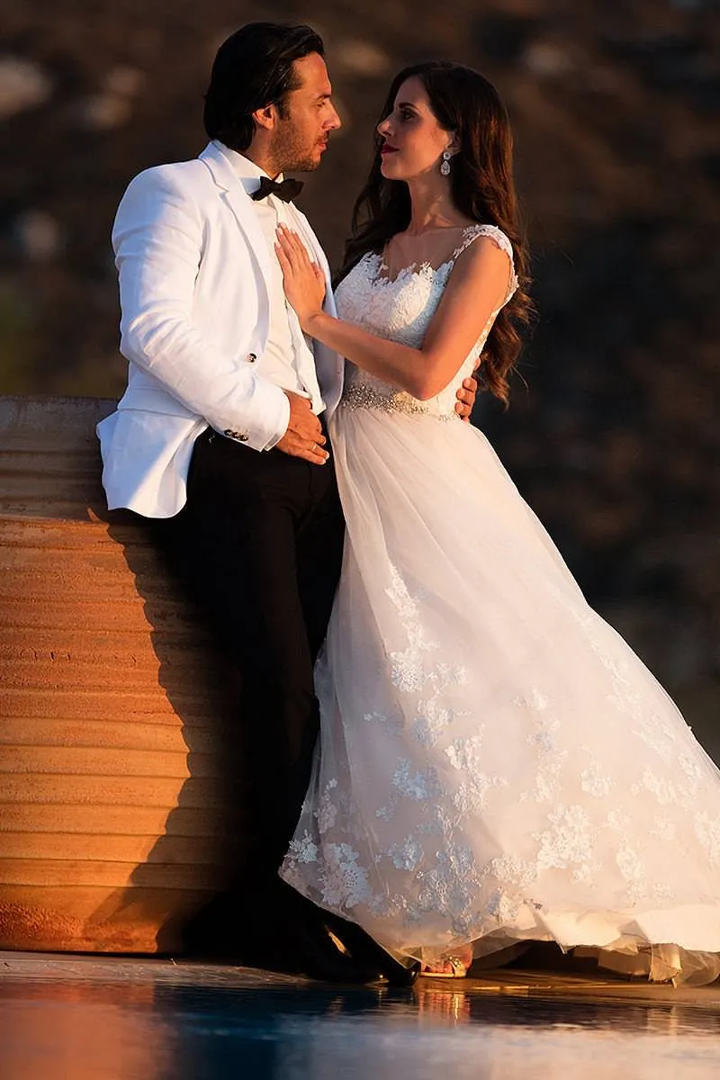 Sunlit sunset wedding photography by a blue dome, in Mykonos, Greece