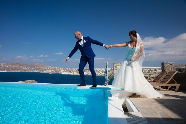 Bride and groom next to swimming pool in Mykonos